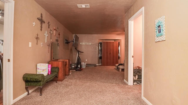 hall with baseboards, visible vents, and carpet floors