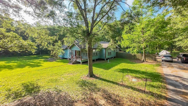 view of front of home with fence and a front lawn