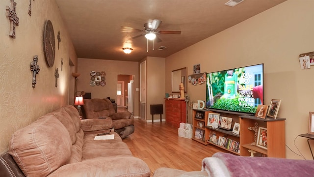living room featuring wood finished floors, a ceiling fan, and visible vents