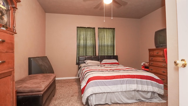 carpeted bedroom with ceiling fan and baseboards