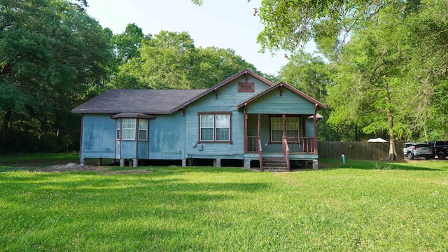 view of front of property featuring fence, a porch, and a front yard