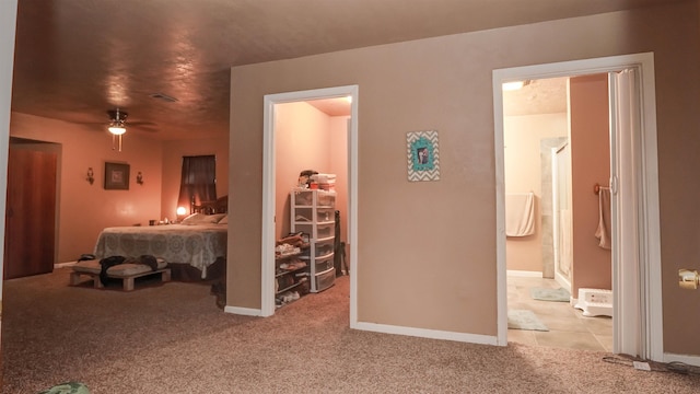bedroom featuring visible vents, ensuite bath, light carpet, and baseboards