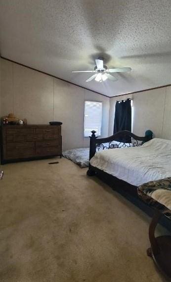 bedroom with ceiling fan, carpet, and a textured ceiling