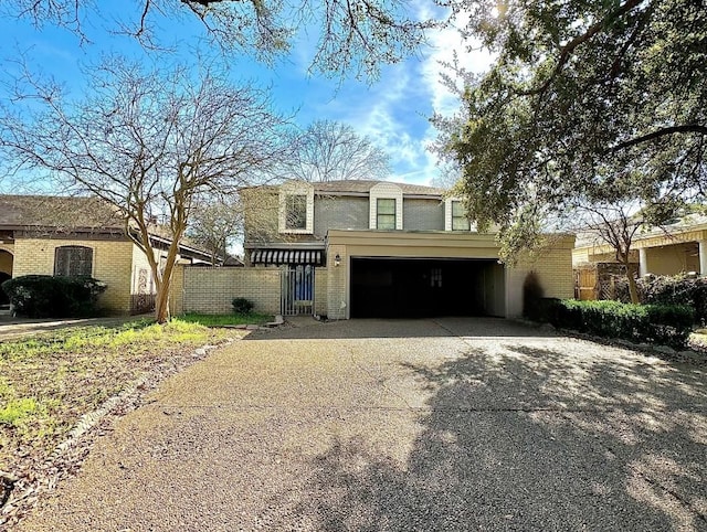 view of front facade featuring driveway, a garage, fence, and brick siding