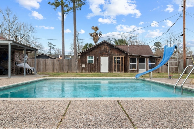 view of pool with an outbuilding, a patio area, and a water slide