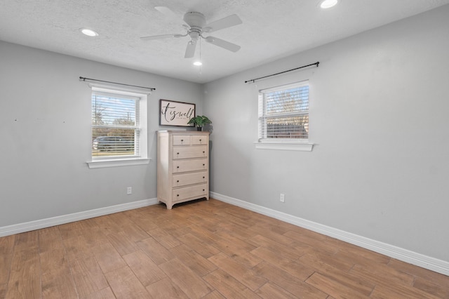 empty room featuring ceiling fan, a textured ceiling, and light hardwood / wood-style floors