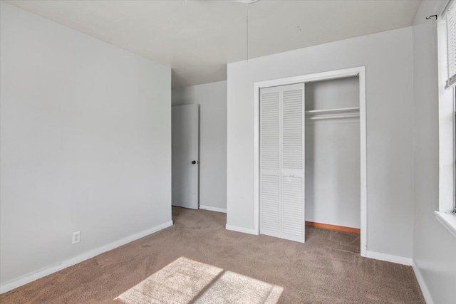 unfurnished bedroom with carpet floors and a closet