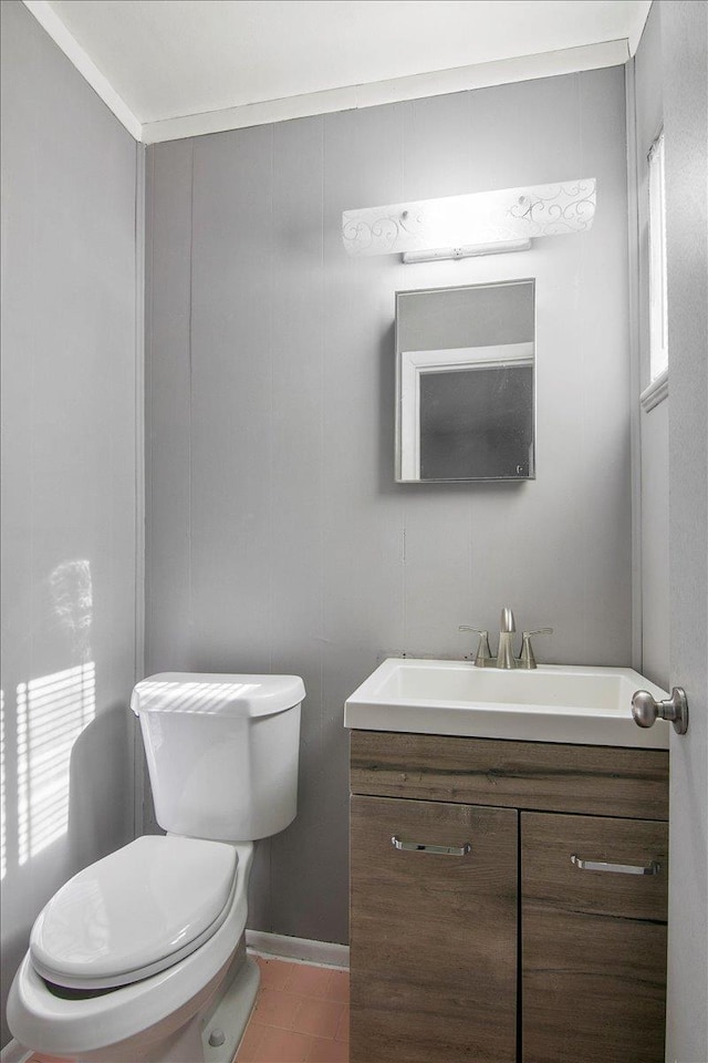 bathroom with tile patterned flooring, vanity, toilet, and crown molding