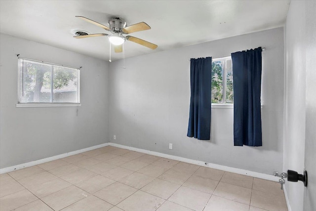 tiled spare room featuring ceiling fan