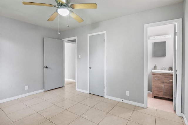 unfurnished bedroom with connected bathroom, ceiling fan, sink, and light tile patterned floors