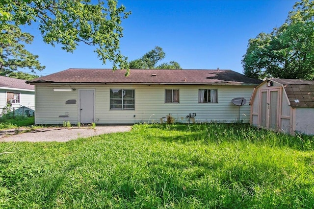 rear view of property with a storage shed