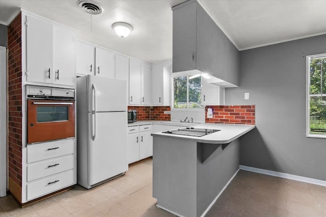 kitchen with black appliances, white cabinets, crown molding, decorative backsplash, and kitchen peninsula