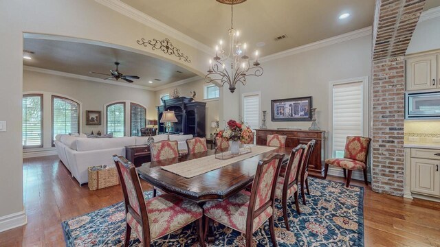 7705 Savannah St, Beaumont, TX 77707 - dining space featuring light wood-style floors, crown molding, a ceiling fan, arched walkways, and a chandelier