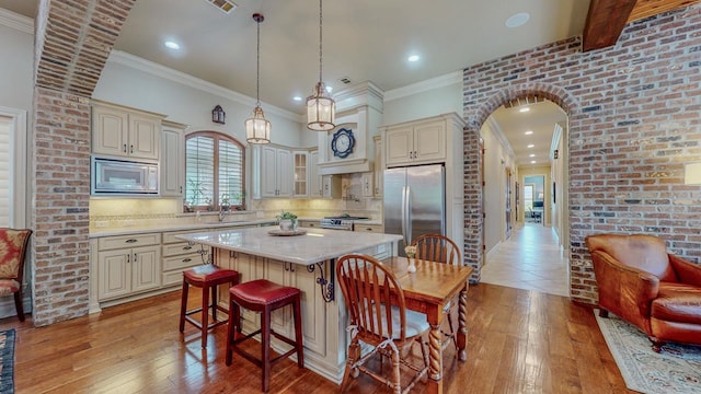 7705 Savannah St, Beaumont, TX 77707 - kitchen with stainless steel appliances, cream cabinets, a sink, recessed lighting, and ornamental molding