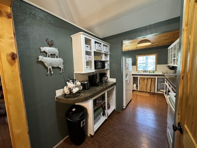 kitchen with white refrigerator with ice dispenser, dark hardwood / wood-style floors, tasteful backsplash, white cabinetry, and sink