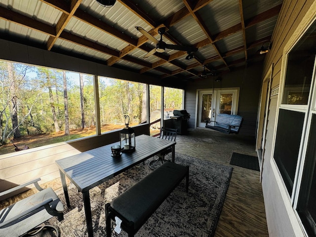 sunroom with ceiling fan and vaulted ceiling with beams