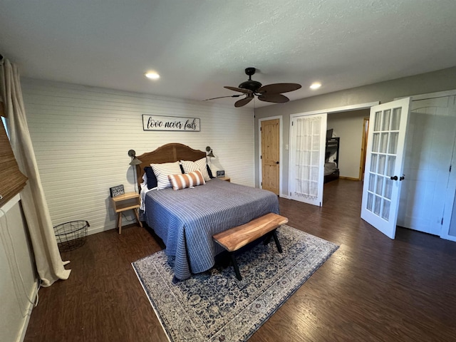 bedroom featuring ceiling fan, dark hardwood / wood-style flooring, french doors, and a textured ceiling