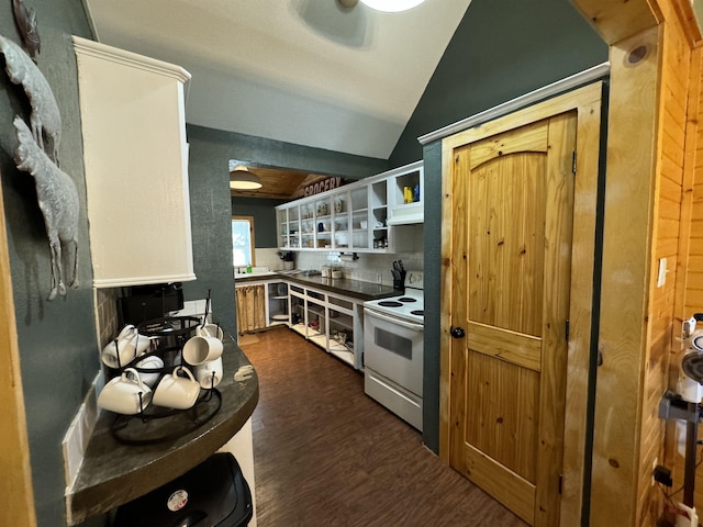 kitchen with white electric range, tasteful backsplash, vaulted ceiling, and dark hardwood / wood-style floors