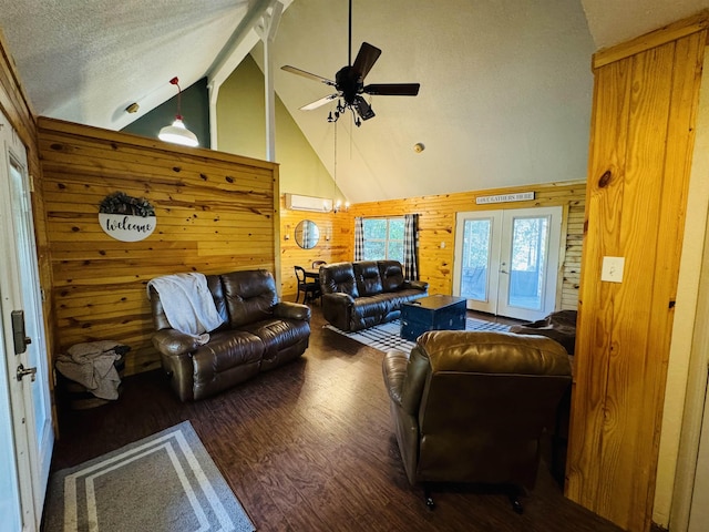 living room featuring wood walls, dark wood-type flooring, a wall mounted air conditioner, a textured ceiling, and ceiling fan with notable chandelier