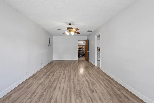 305 White Oak Trl, Bridge City, TX 77611 - unfurnished living room with light wood-type flooring, a ceiling fan, baseboards, and a textured ceiling