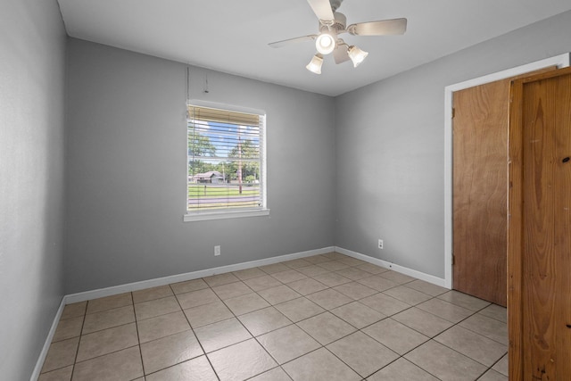 305 White Oak Trl, Bridge City, TX 77611 - unfurnished bedroom featuring light tile patterned floors, baseboards, and a ceiling fan