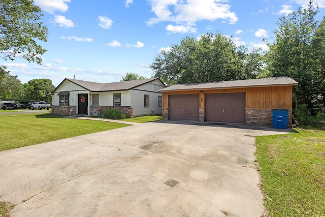 305 White Oak Trl, Bridge City, TX 77611 - view of front of house with a garage, a front lawn, board and batten siding, driveway, and an outbuilding