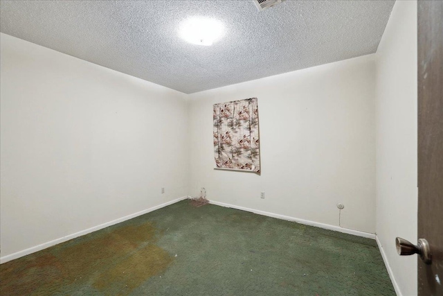 carpeted empty room with baseboards and a textured ceiling