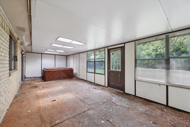 unfurnished sunroom with visible vents and a hot tub