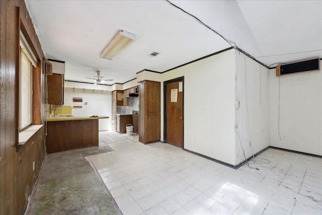 kitchen featuring light floors, ceiling fan, a sink, visible vents, and a peninsula