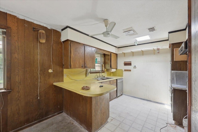 kitchen featuring stainless steel dishwasher, a sink, visible vents, light countertops, and a peninsula