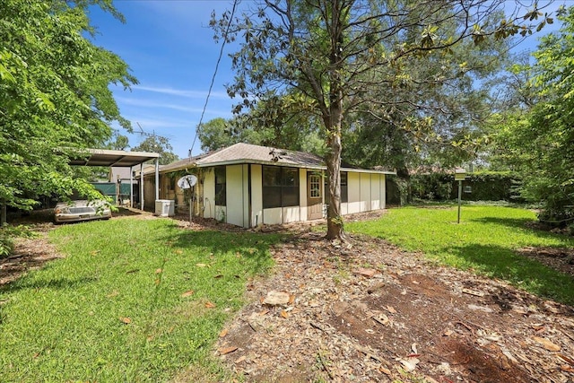 back of property with a lawn and central air condition unit