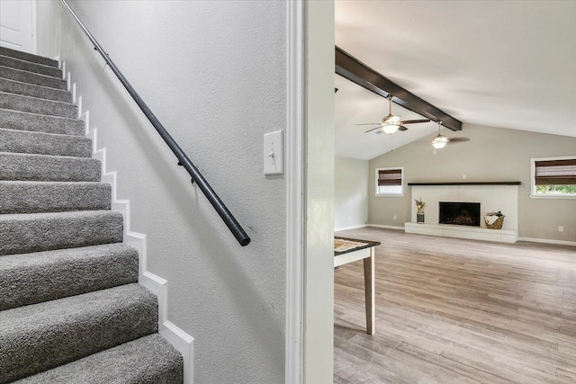 stairs featuring hardwood / wood-style floors, ceiling fan, plenty of natural light, and lofted ceiling with beams