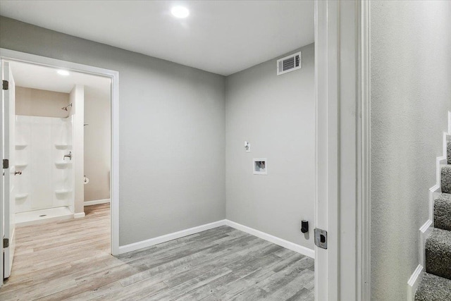 clothes washing area featuring washer hookup and light hardwood / wood-style floors