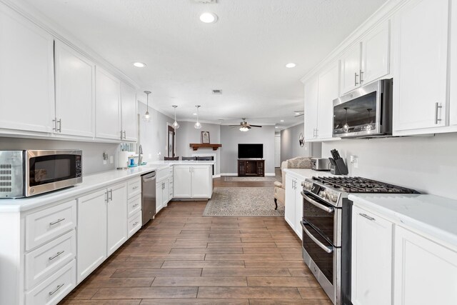 314 Pinehurst Dr, Sour Lake, TX 77659 - kitchen with white cabinets, a ceiling fan, appliances with stainless steel finishes, open floor plan, and a peninsula