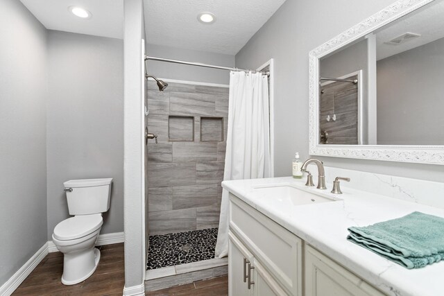314 Pinehurst Dr, Sour Lake, TX 77659 - full bathroom featuring toilet, baseboards, wood finished floors, and tiled shower