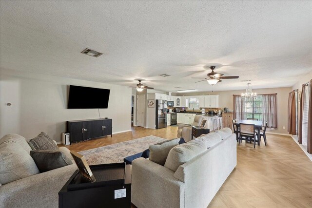504 County Road 763 N, Buna, TX 77612 - living room featuring a chandelier, ceiling fan, a textured ceiling, and baseboards