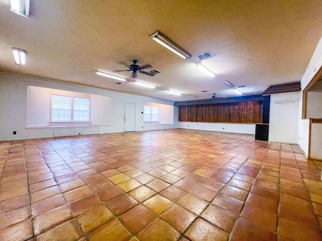 spare room with ceiling fan, light tile patterned floors, and a textured ceiling