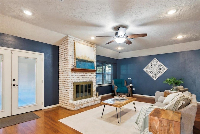 living room with french doors, a textured ceiling, ceiling fan, wood-type flooring, and lofted ceiling