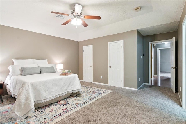 carpeted bedroom with ceiling fan and a textured ceiling