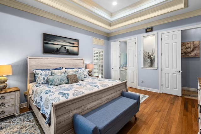 7675 Myrtle Beach Dr, Beaumont, TX 77707 - bedroom featuring crown molding, a tray ceiling, wood finished floors, and ensuite bathroom