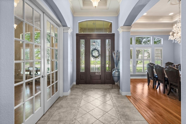 7675 Myrtle Beach Dr, Beaumont, TX 77707 - foyer featuring french doors, ornamental molding, inlaid floor details, a chandelier, and decorative columns
