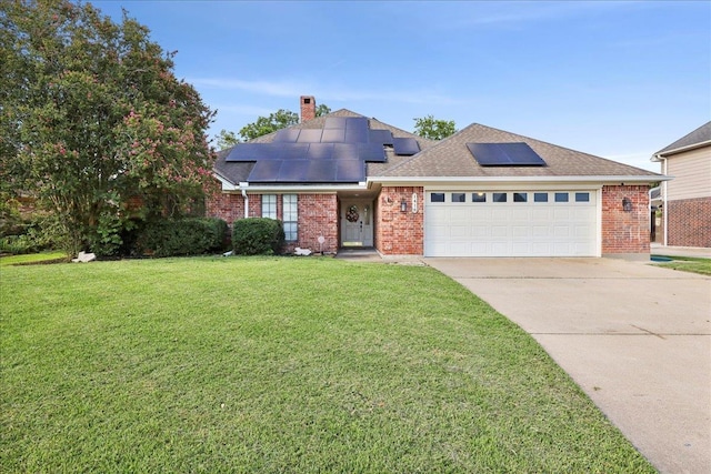 1416 23rd St, Nederland, TX 77627 - view of front of property featuring a front yard, driveway, a garage, brick siding, and solar panels