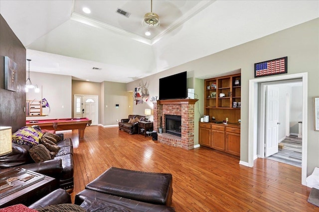 1416 23rd St, Nederland, TX 77627 - living room featuring billiards table, a ceiling fan, light wood-style flooring, a brick fireplace, and ornamental molding