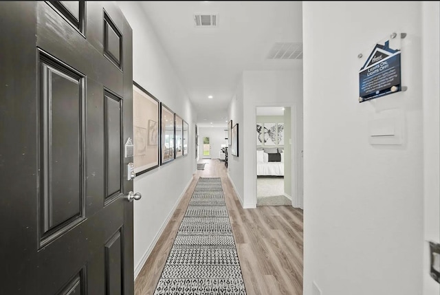 corridor featuring recessed lighting, light wood-style floors, visible vents, and baseboards