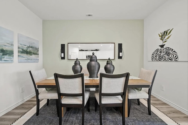 dining room with visible vents, baseboards, and wood finished floors