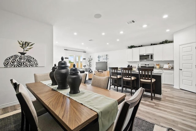 dining space with light wood-type flooring, visible vents, baseboards, and recessed lighting