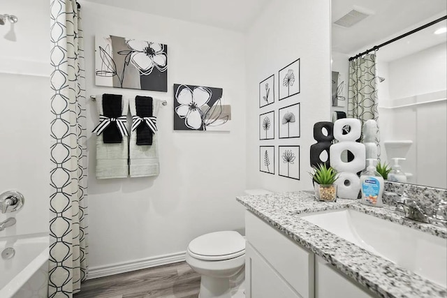 full bath with baseboards, toilet, shower / bath combo, wood finished floors, and vanity