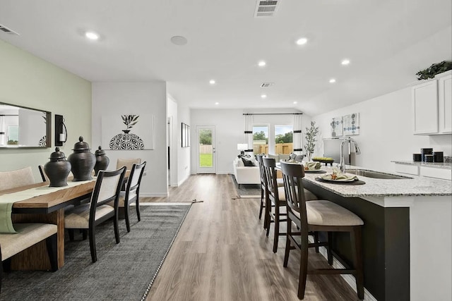 dining room with recessed lighting, visible vents, lofted ceiling, and light wood-style flooring