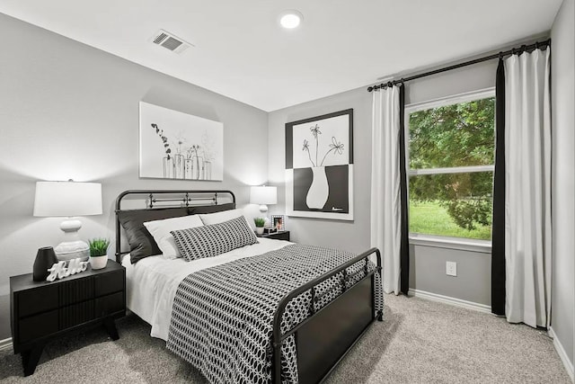 carpeted bedroom featuring multiple windows, baseboards, and visible vents