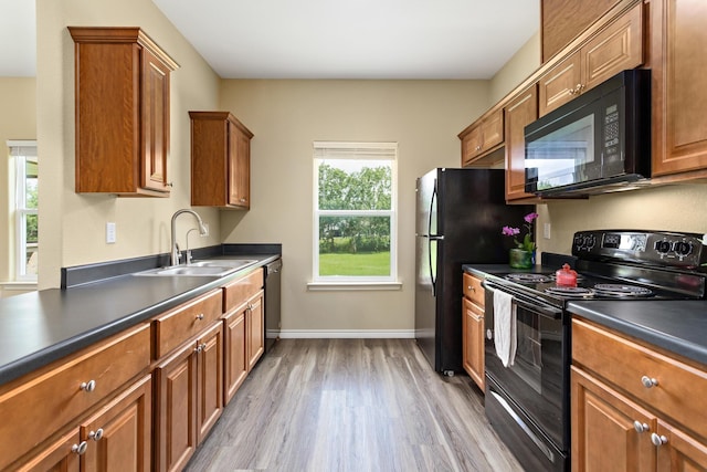 451 Lene Ln, Beaumont, TX 77705 - kitchen with black appliances, light wood-type flooring, dark countertops, and brown cabinets